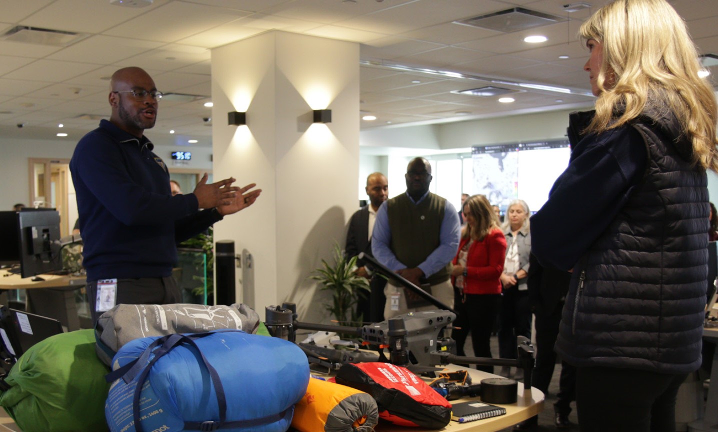 Photo of people standing next to a table with emergency supplies on it