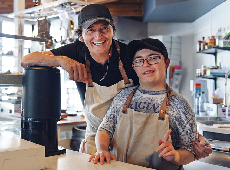 A person with a developmental disability and another person working together at a café.
