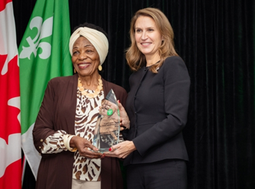 The Honorable Caroline Mulroney, Minister of Francophone Affairs, presents the Minister of Francophone Affairs Award to Fété Ngira‑Batware Kimpiobi, Executive Director of Solidarité des femmes immigrantes francophones du Niagara.