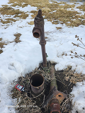 Un puits rouillé avec une pile de débris.